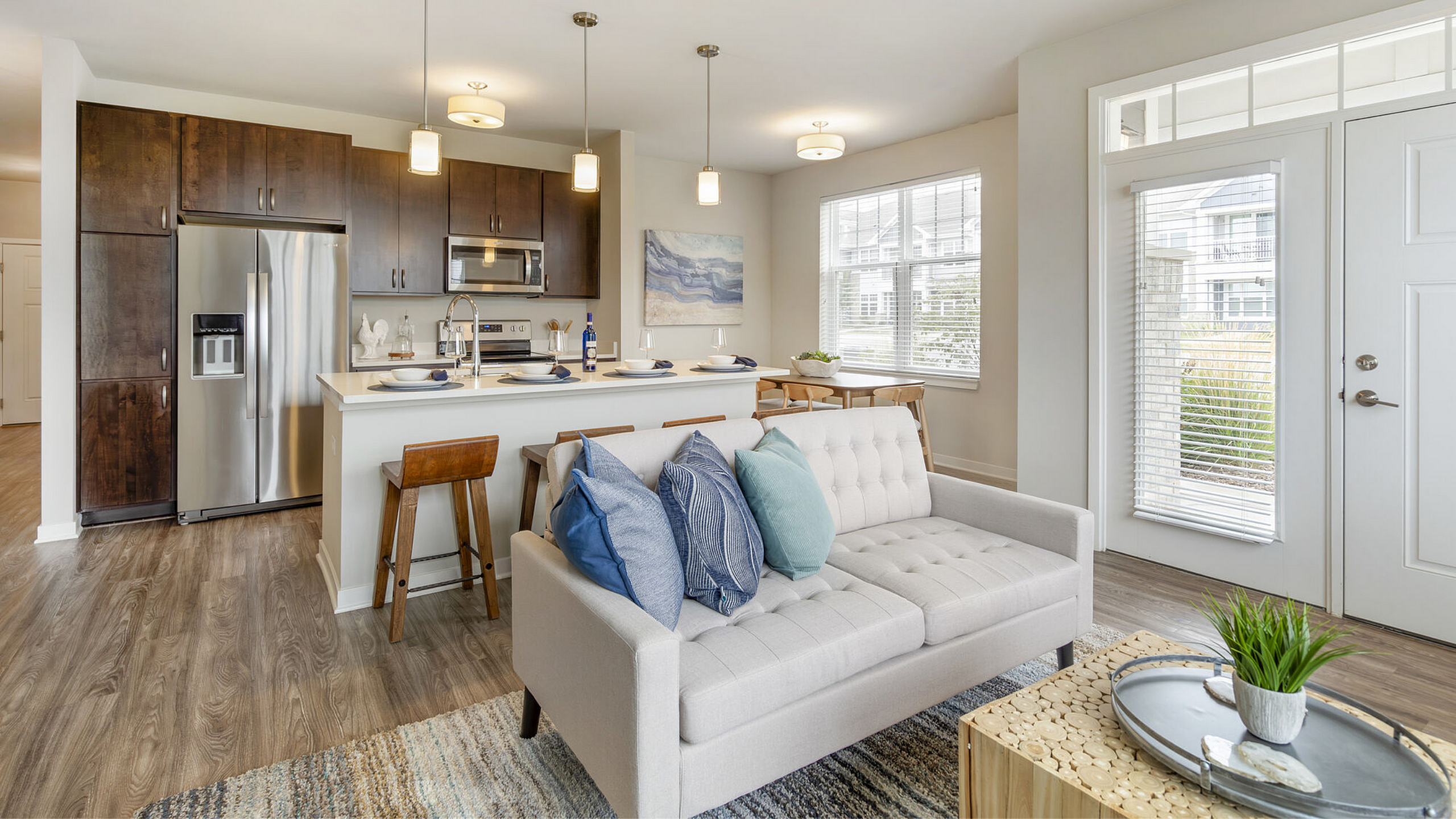 Bright modern kitchen and living area with elegant wooden flooring, cozy sofa, and stylish decor creating a welcoming atmosphere.