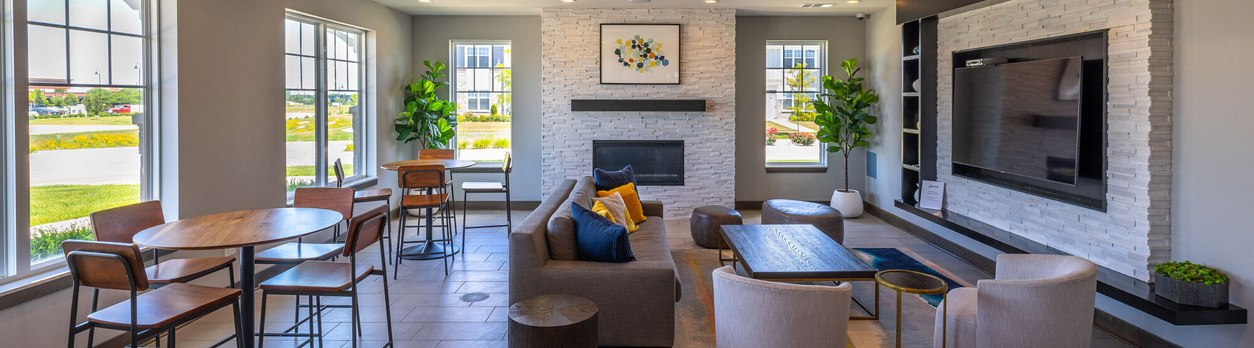 Inviting modern lounge area with stylish decor, featuring comfortable seating, large windows with scenic views, and a sophisticated entertainment setup.