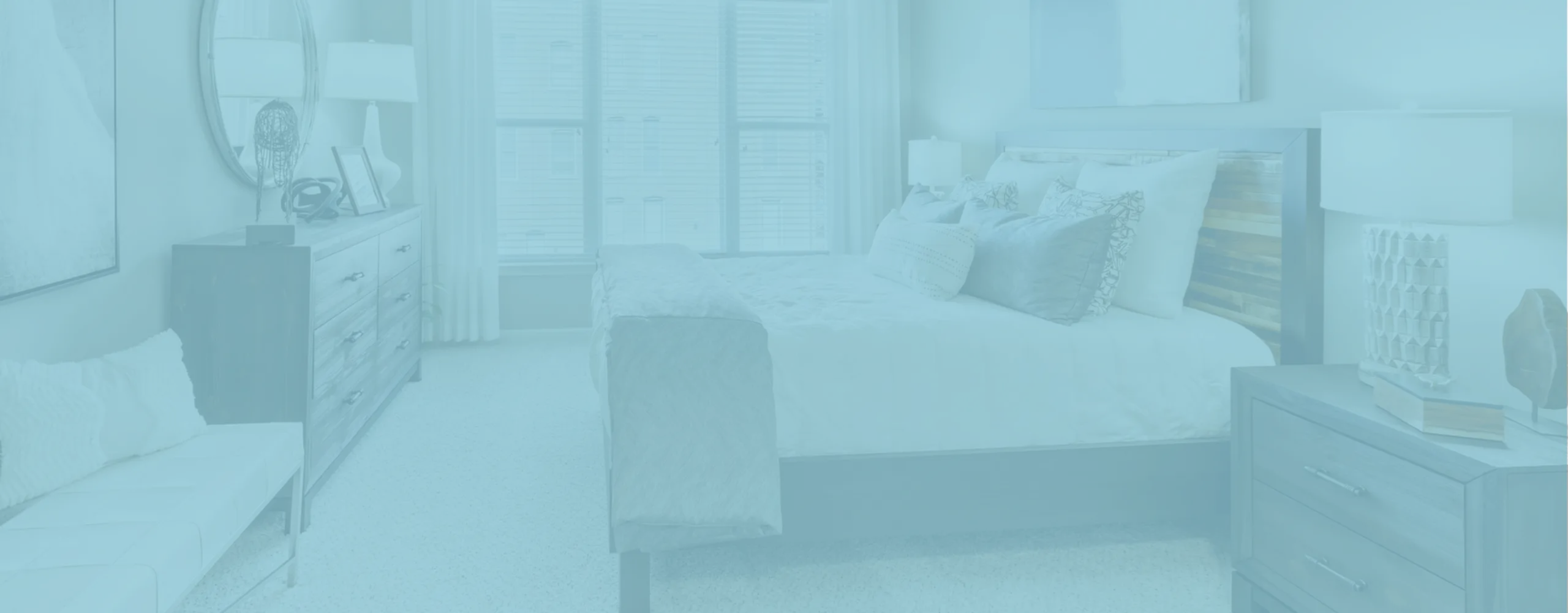 Inviting bedroom with elegant decor, large window bringing natural light, and modern wooden furniture.