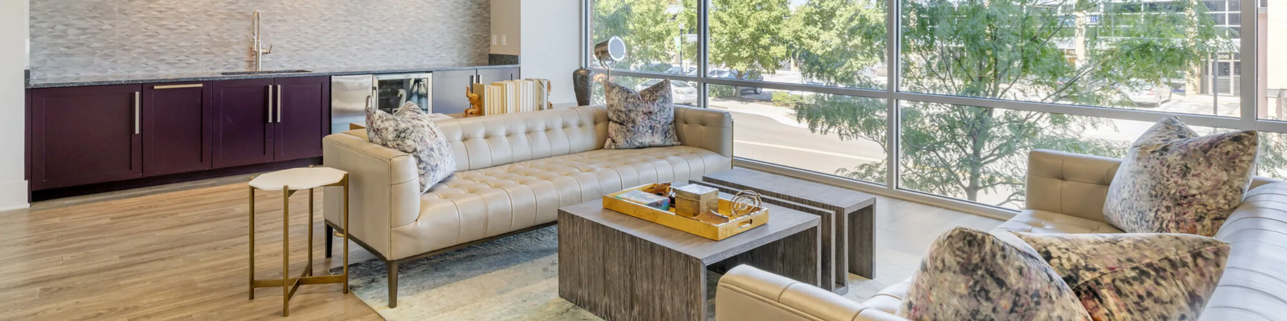 Contemporary kitchen with sleek cabinetry, modern appliances, and elegant pendant lighting, bathed in natural light from large windows.
