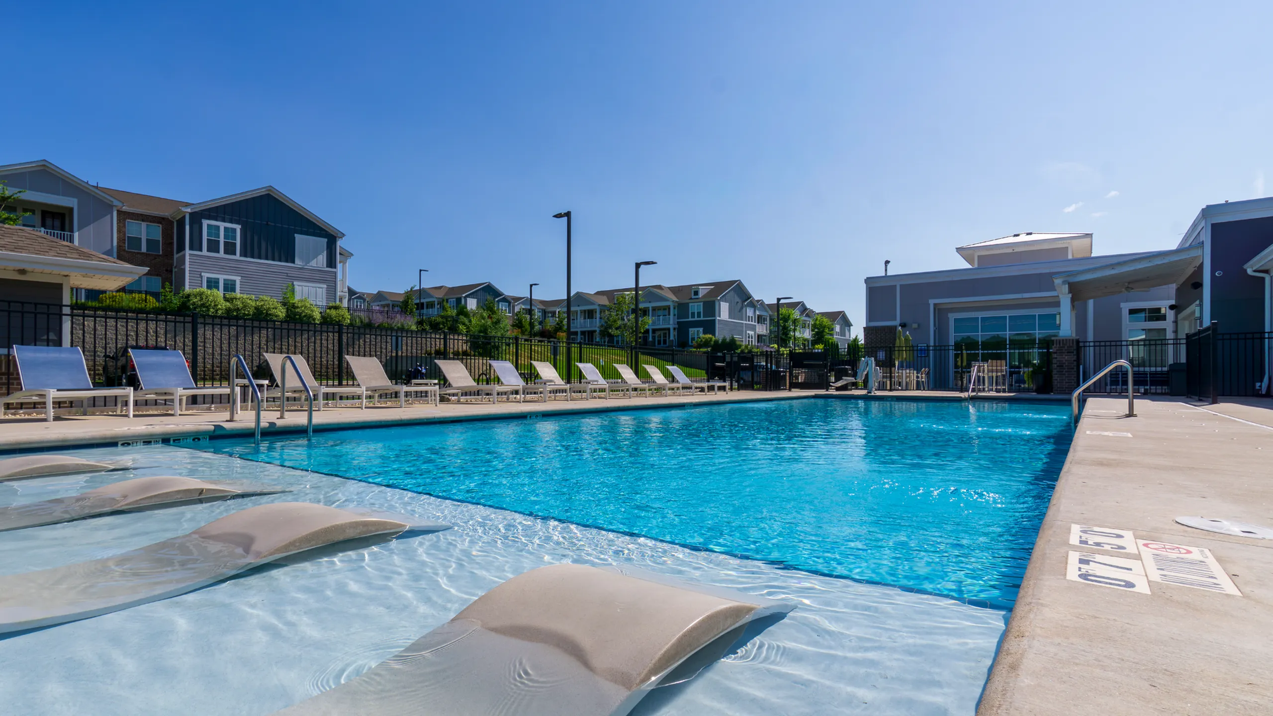 Charming suburban apartment complex surrounded by lush greenery, featuring modern architecture and ample parking spaces.