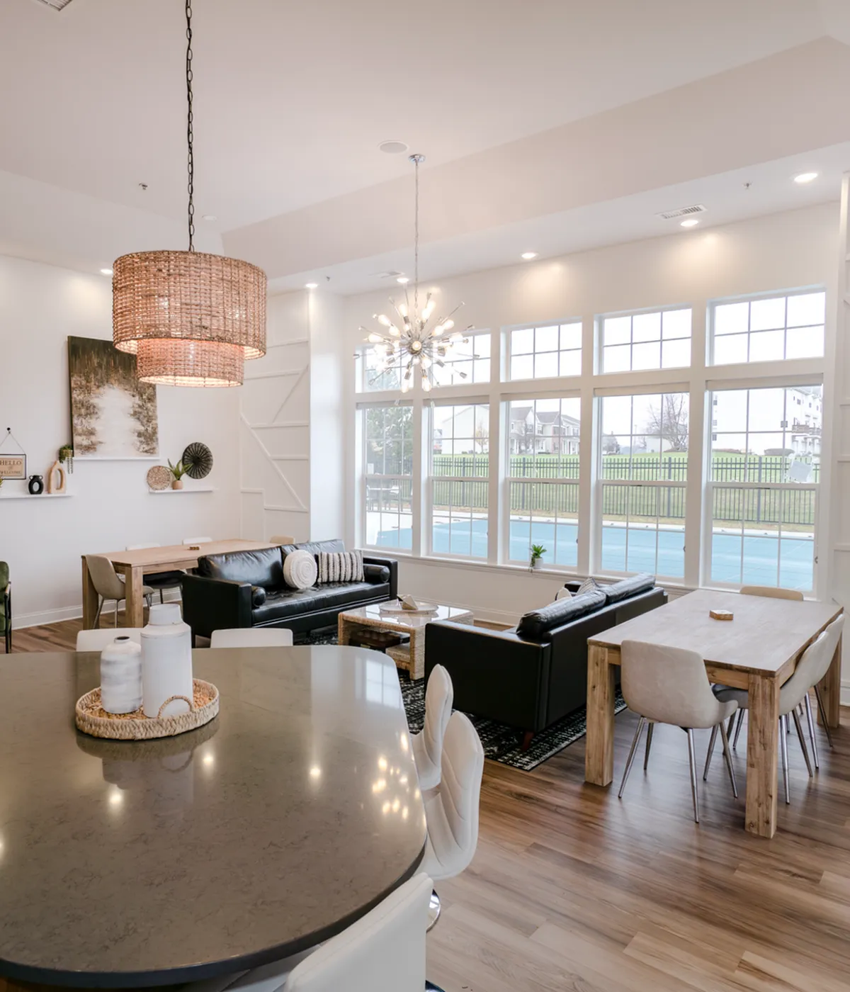Inviting community pool area with ample sun loungers and a charming clubhouse, perfect for relaxation and social gatherings under a clear blue sky.