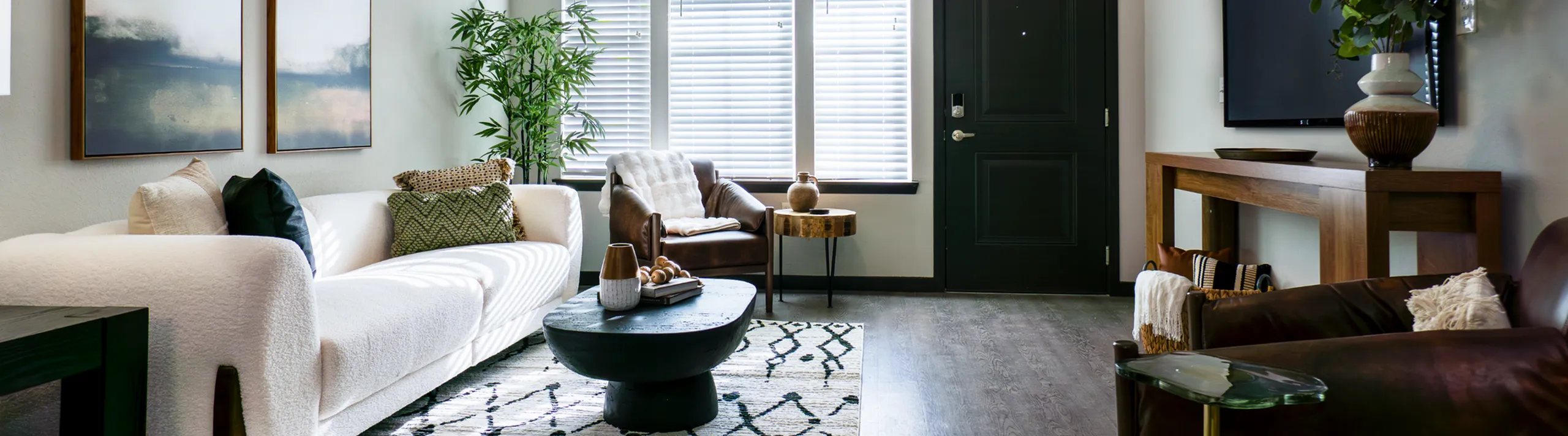 Chic living room with modern decor, featuring a cozy white sofa, stylish armchair, and accent pieces, bathed in natural light.