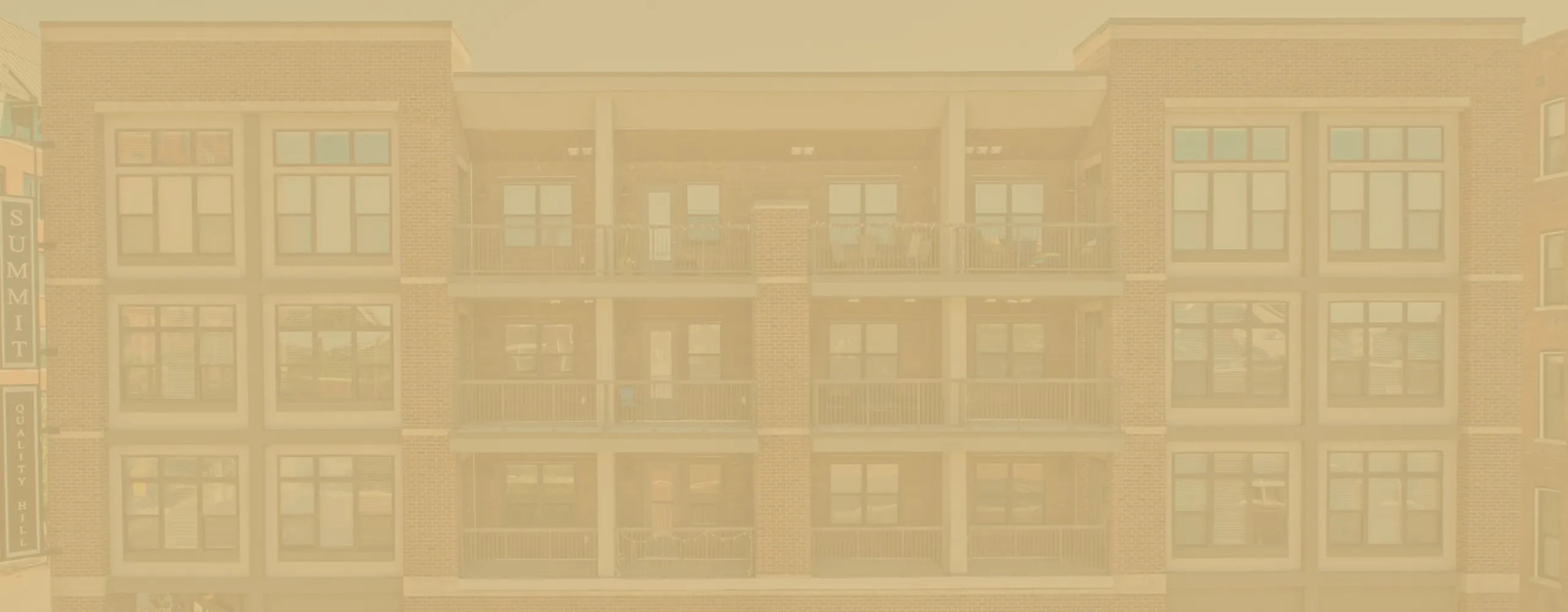 Charming brick apartment building with spacious balconies showcasing modern urban living.
