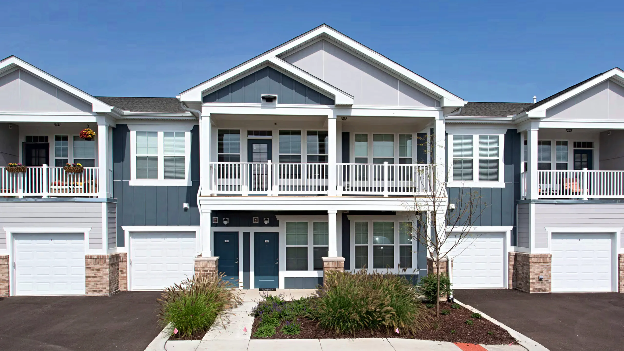 Charming suburban apartment complex surrounded by lush greenery, featuring modern architecture and ample parking spaces.