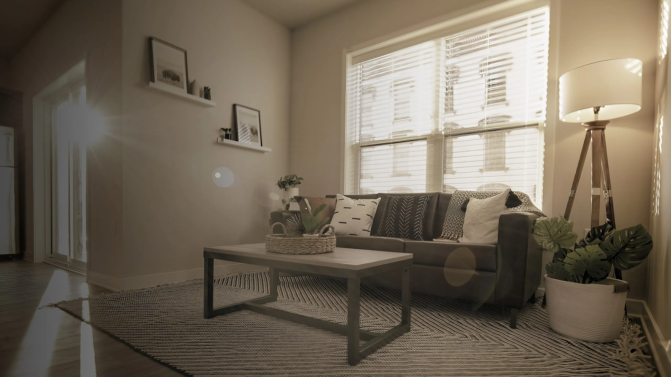 Sunlit living room with a cozy sofa, chic coffee table, modern floor lamp, and elegant decor, showcasing a warm and inviting ambiance.