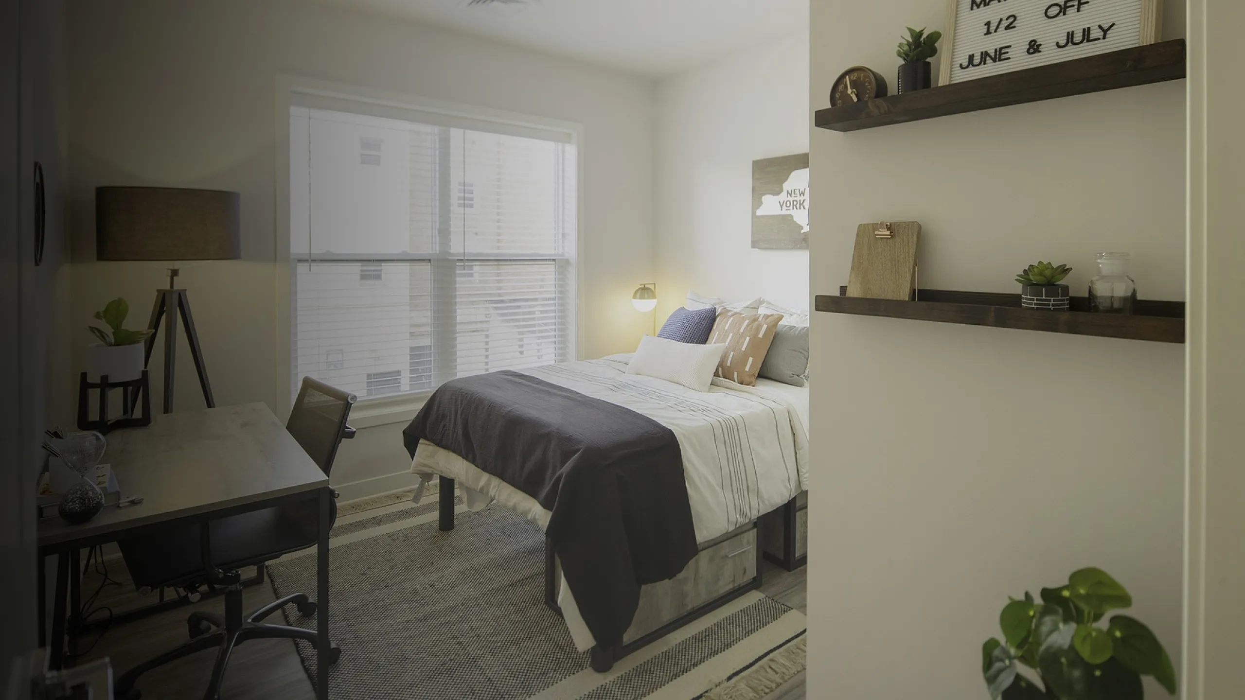 Cozy bedroom with a chic desk setup, stylish shelving, and abundant natural light.