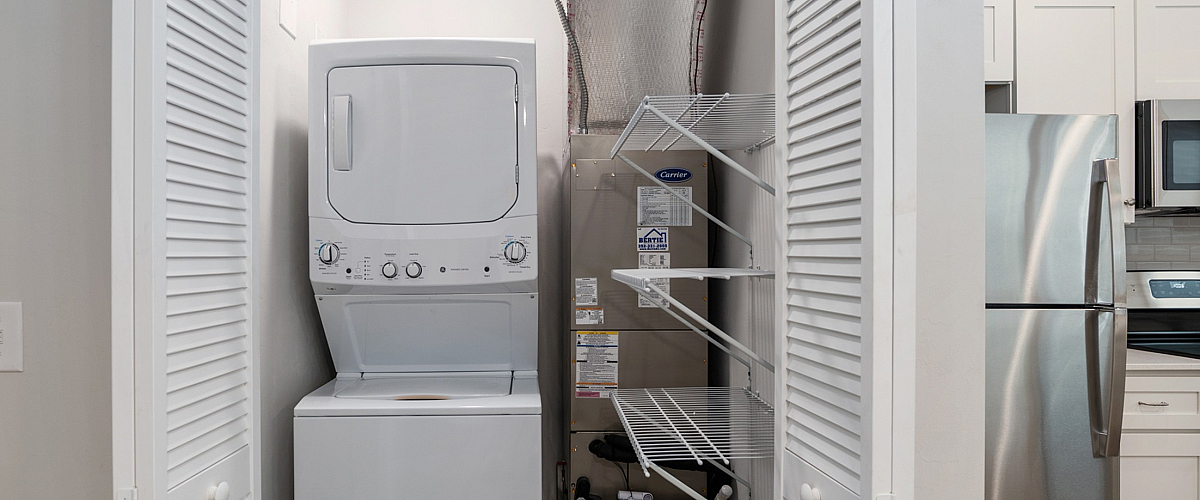 Contemporary apartment with sleek in-unit laundry, stainless steel appliances, and elegant shelving for storage.
