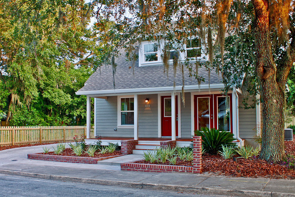 Gray two-story student home with red doors and covered front porch at Old Row at Eastwood near UF Gainesville