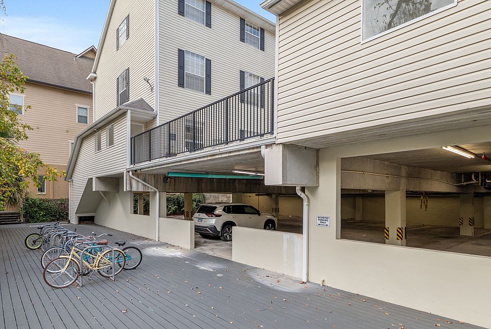 Charming apartment building with secure parking and convenient bicycle racks, surrounded by lush greenery.