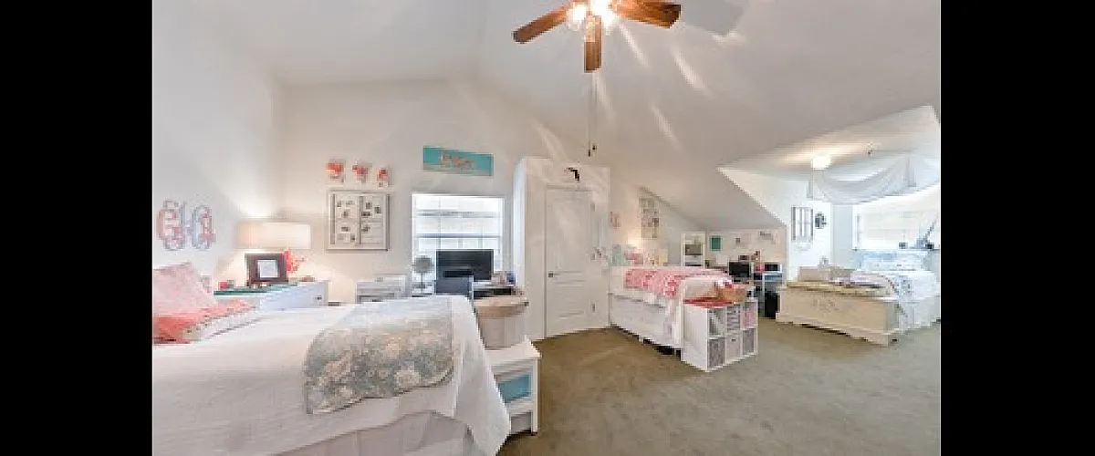 Charming and spacious bedroom with twin beds, cozy ambiance, and ample natural light, ideal for a serene living experience.