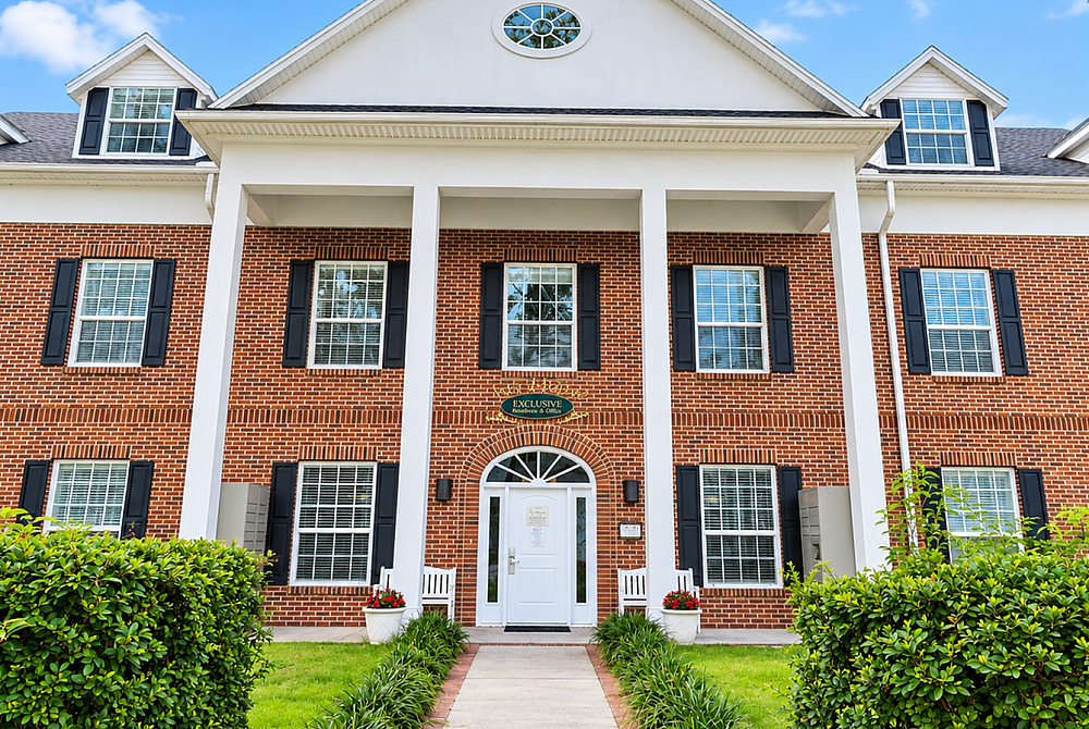 Charming brick apartment building with classic colonial architecture, featuring large windows, manicured landscaping, and welcoming front entrance.