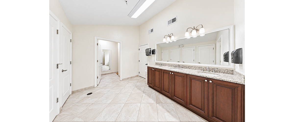 Spacious, modern bathroom with twin sinks, elegant granite countertops, and chic dark wood cabinetry.