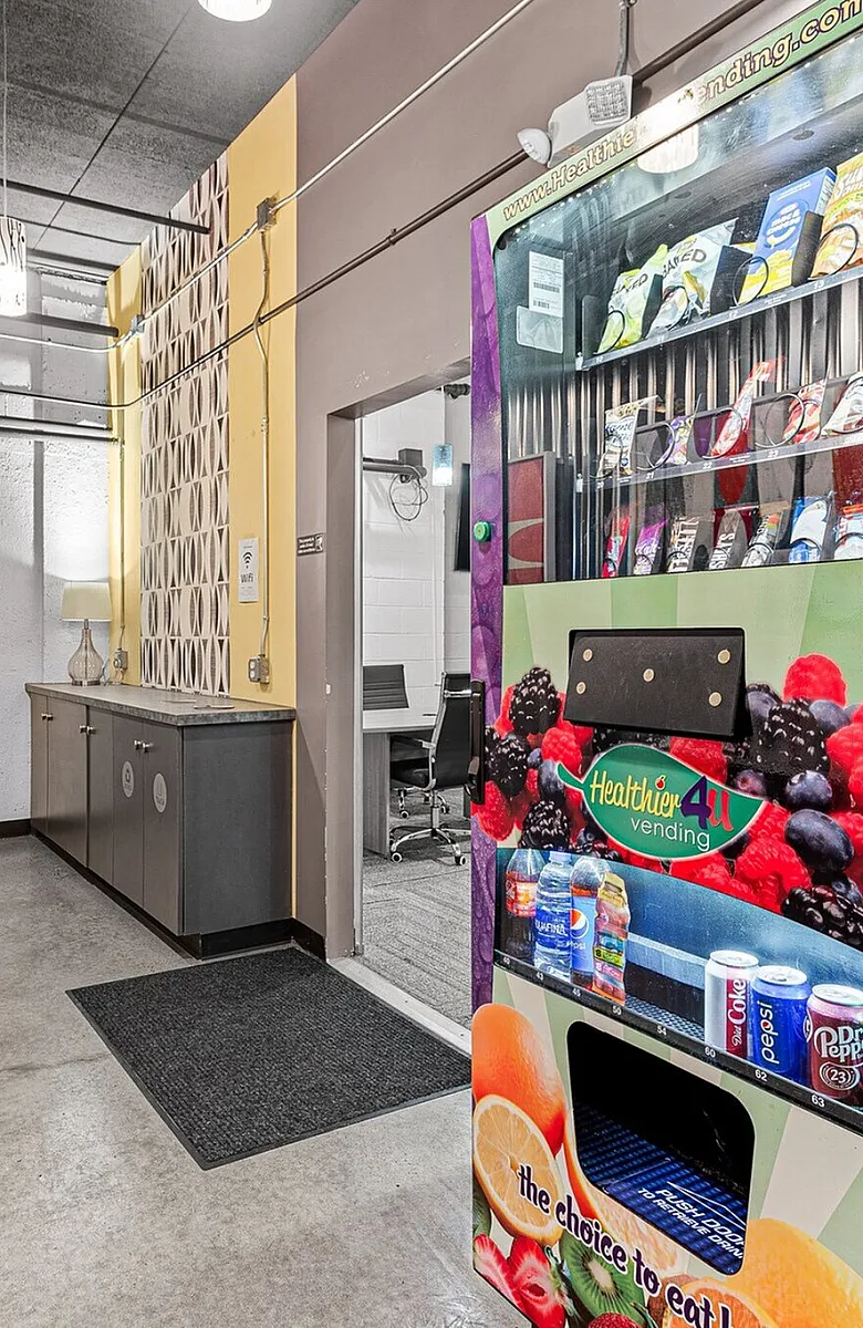 Inviting hallway with vibrant decor and a modern vending machine, offering a glimpse into stylish communal spaces.