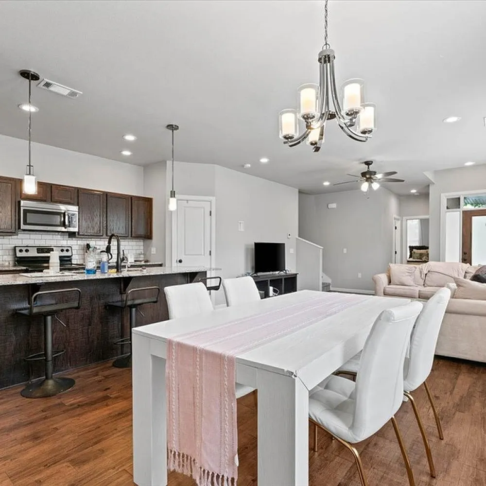 Contemporary open-plan living area showcasing a sleek kitchen with dark wood cabinets, elegant dining space, and cozy lounge for relaxation.