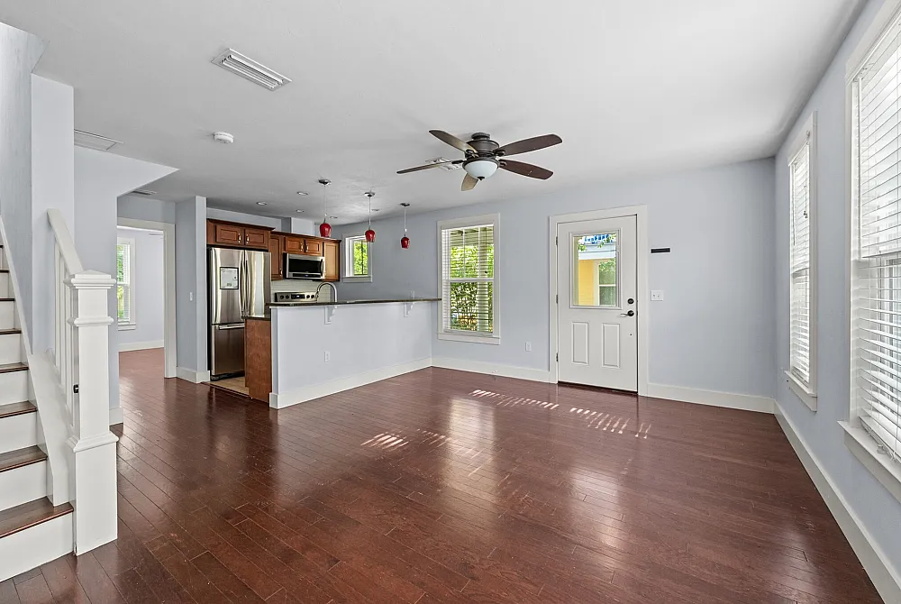 Bright and inviting open-concept living area with hardwood floors and modern kitchen, ideal for entertaining.