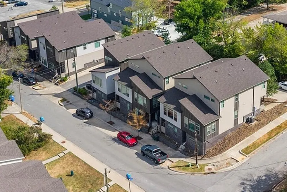 Charming urban street with modern townhouses and lush green foliage, perfect for contemporary city living.