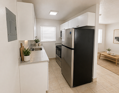 Modern kitchen with sleek stainless steel appliances, ample cabinet space, and bright natural light, seamlessly connecting to a cozy, stylish living room.