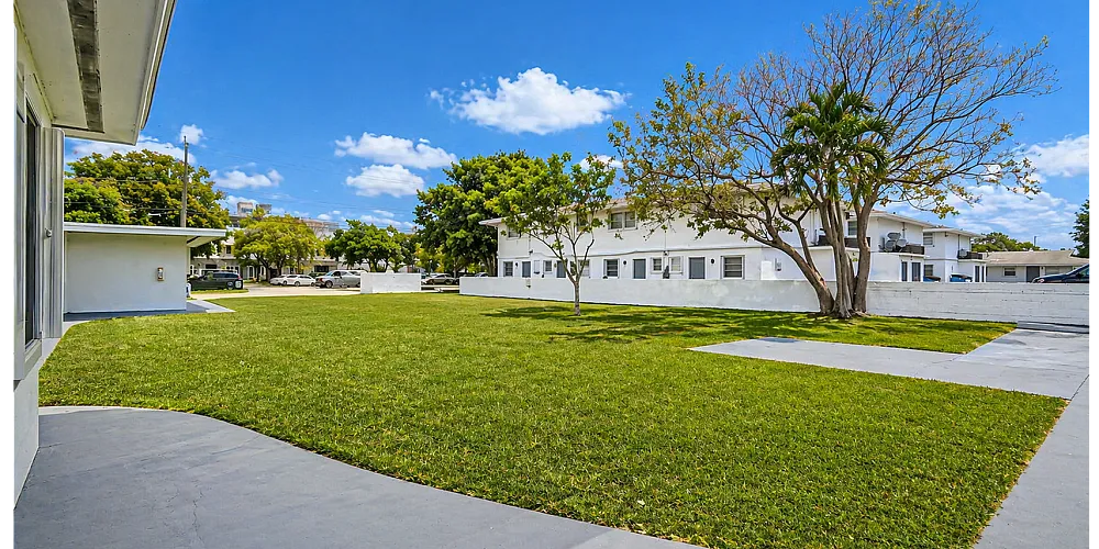 Expansive open courtyard with lush greenery and a serene atmosphere, perfect for outdoor relaxation.