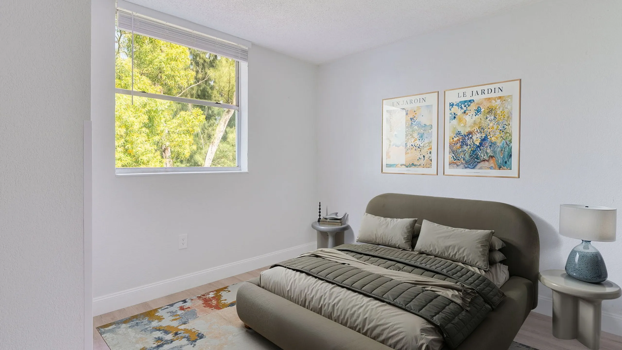 Bright and serene bedroom with a cozy double bed, modern side table, and large window offering lush green views, ideal for relaxation.