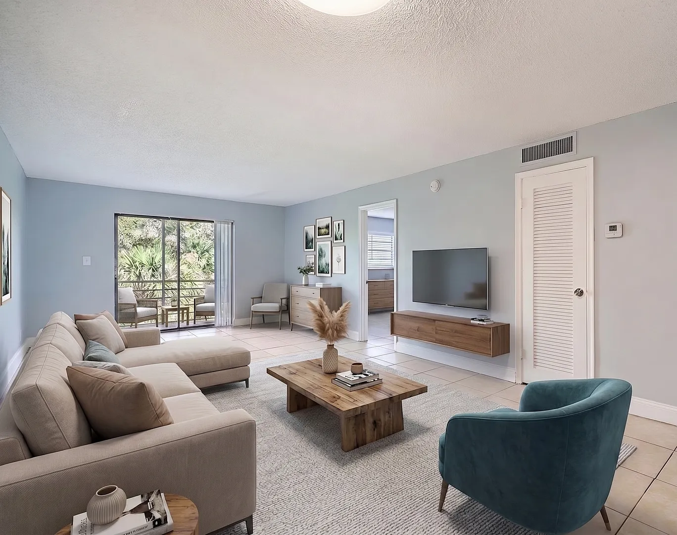 Bright living room with modern decor, cozy beige sectional, and elegant wooden accents. Large window offers lush greenery views, enhancing the serene atmosphere.