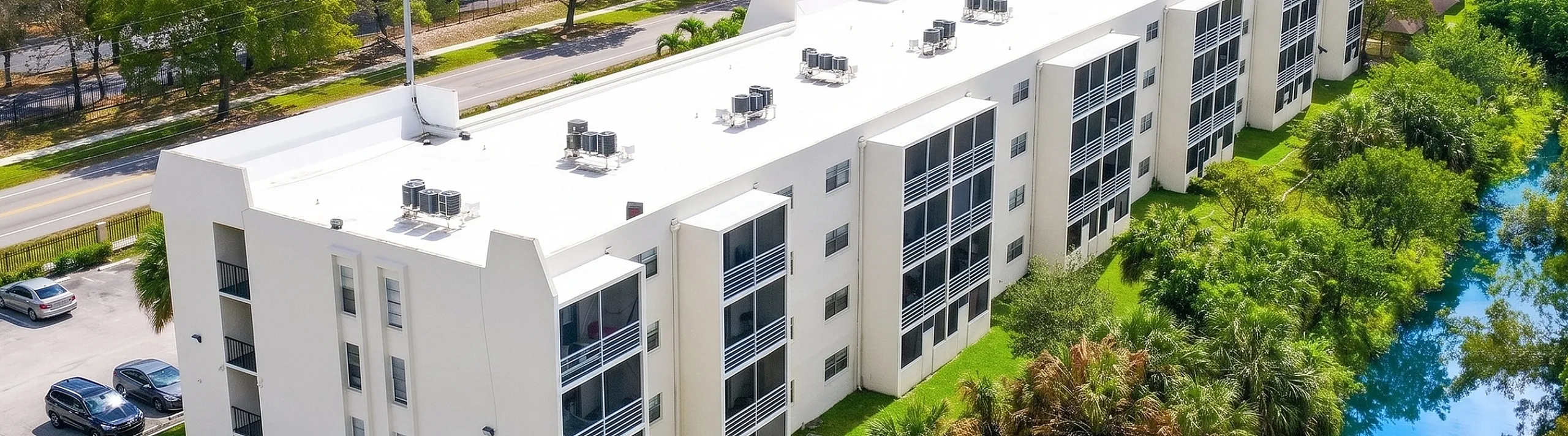 Aerial view of The Canal Views Residences, showcasing modern apartment buildings surrounded by lush greenery and a serene canal.