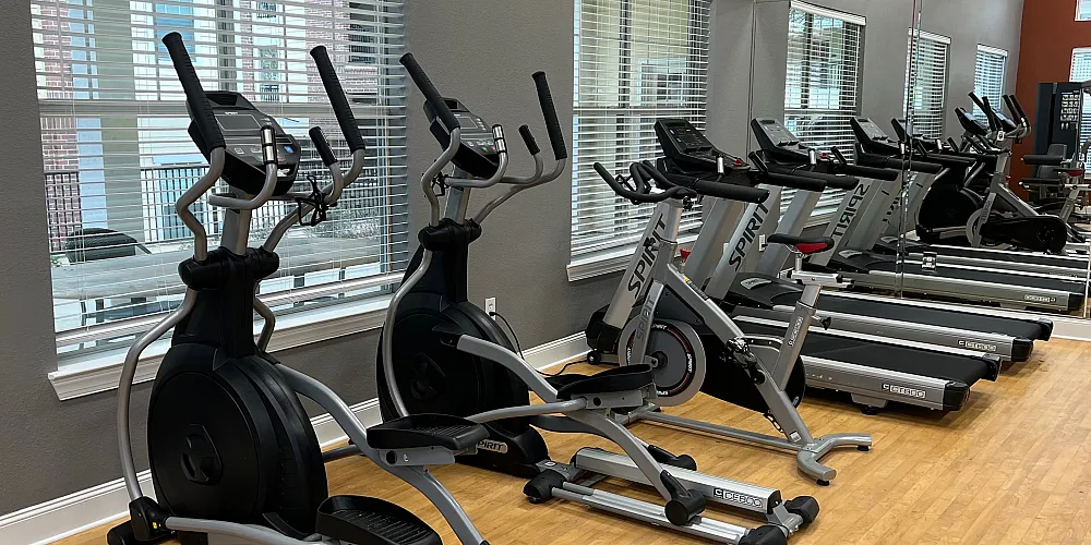Modern fitness center equipped with state-of-the-art exercise bikes and sleek wooden floors.