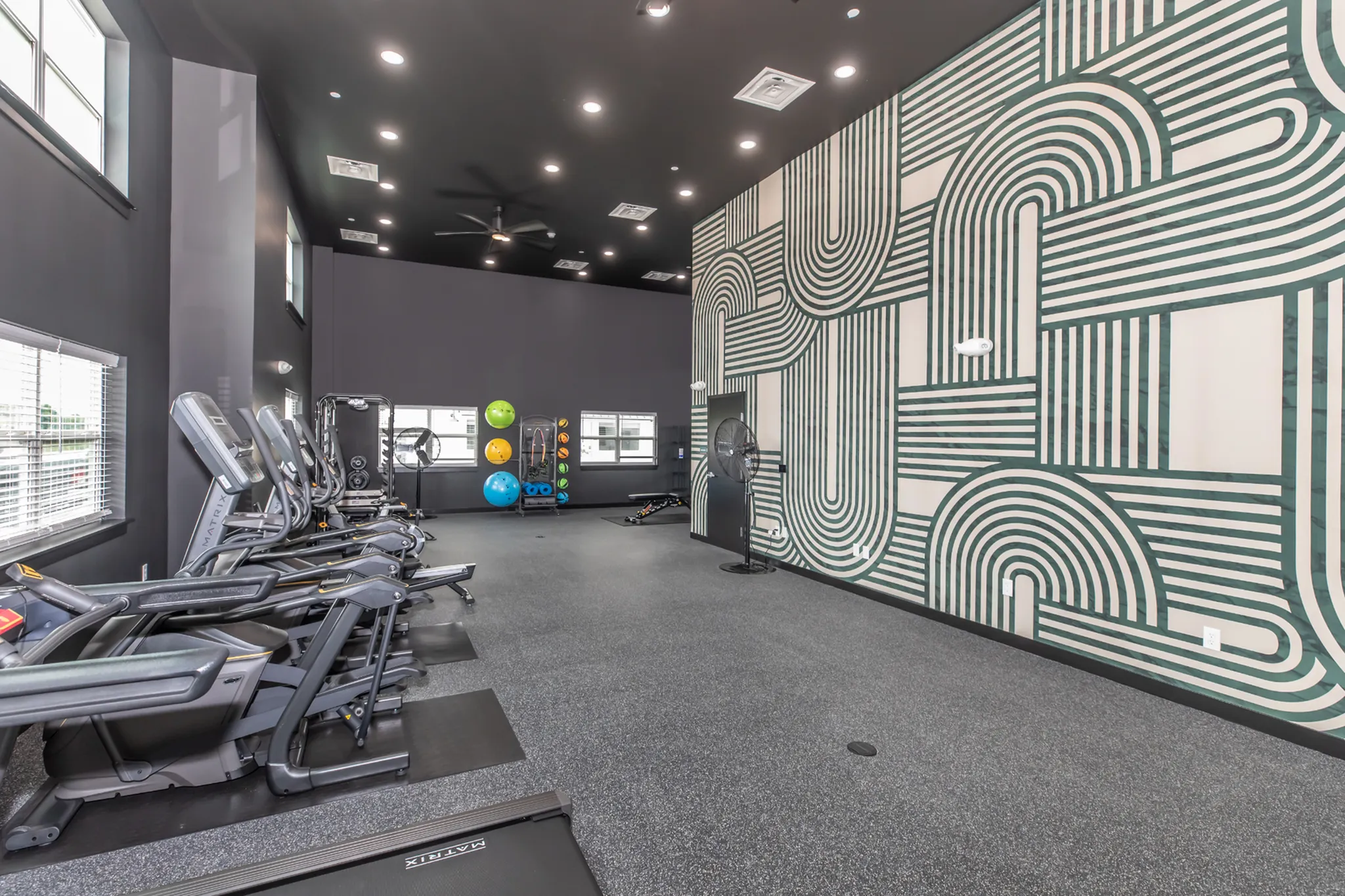 Modern fitness center with state-of-the-art treadmills and vibrant wall art in a spacious environment.