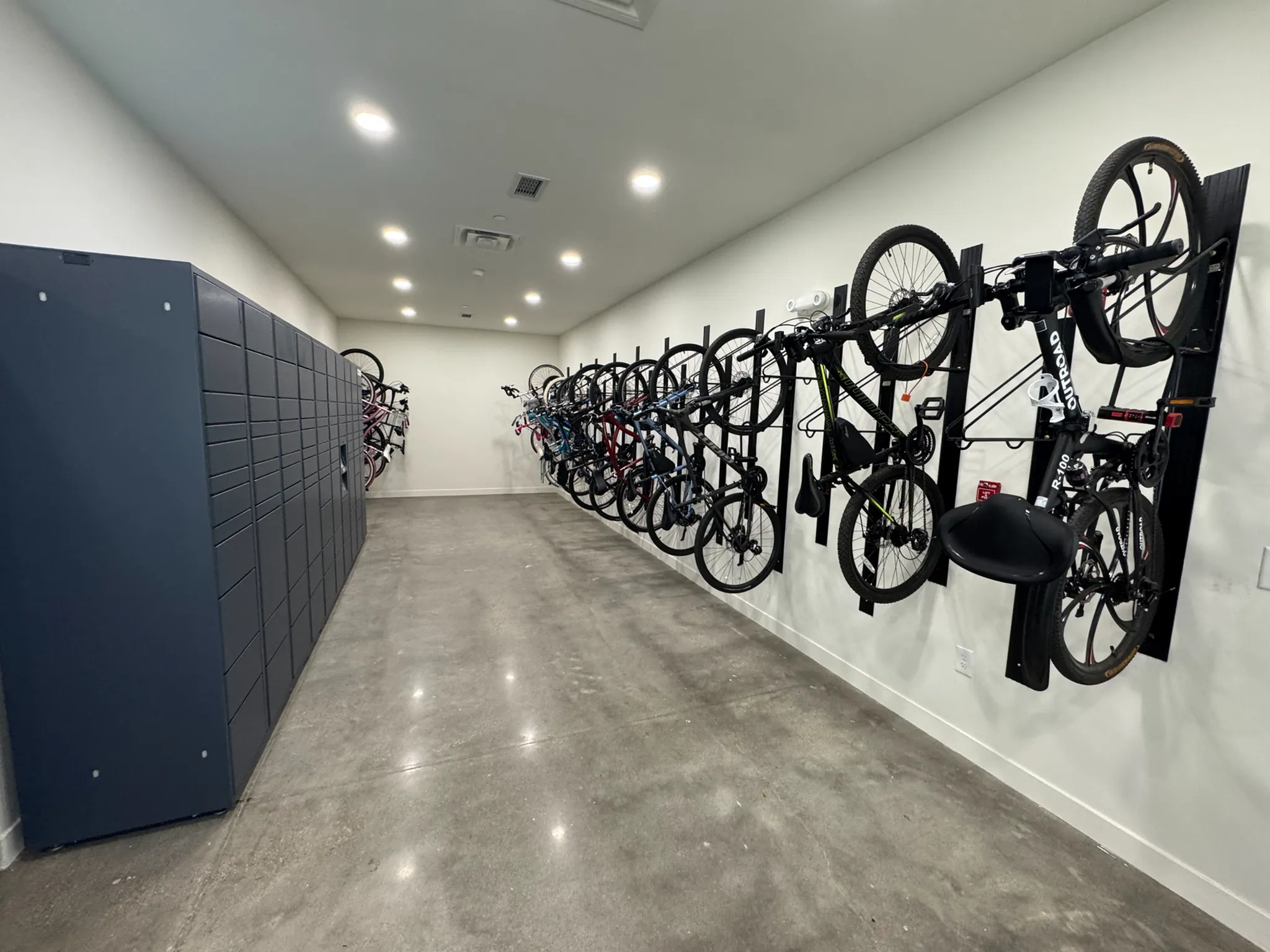 Modern bike storage room with secure lockers and sleek vertical racks for convenient organization.