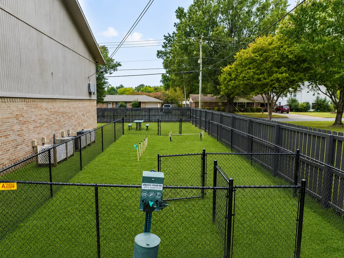 Inviting pet-friendly outdoor play area with agility equipment and fenced surroundings, perfect for active pets and relaxation.