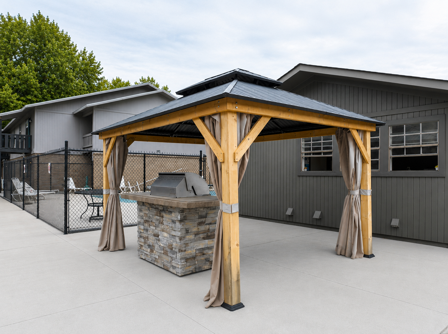 Charming outdoor area featuring a stylish gazebo with a built-in barbecue grill, perfect for entertaining, set against modern architecture.