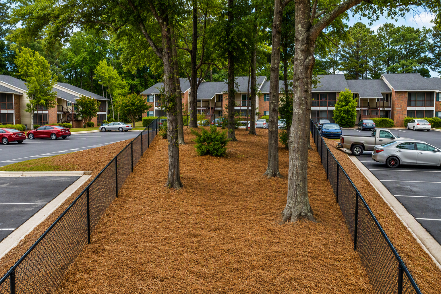 Charming apartment complex with lush greenery, ample parking, and serene outdoor space perfect for relaxation.