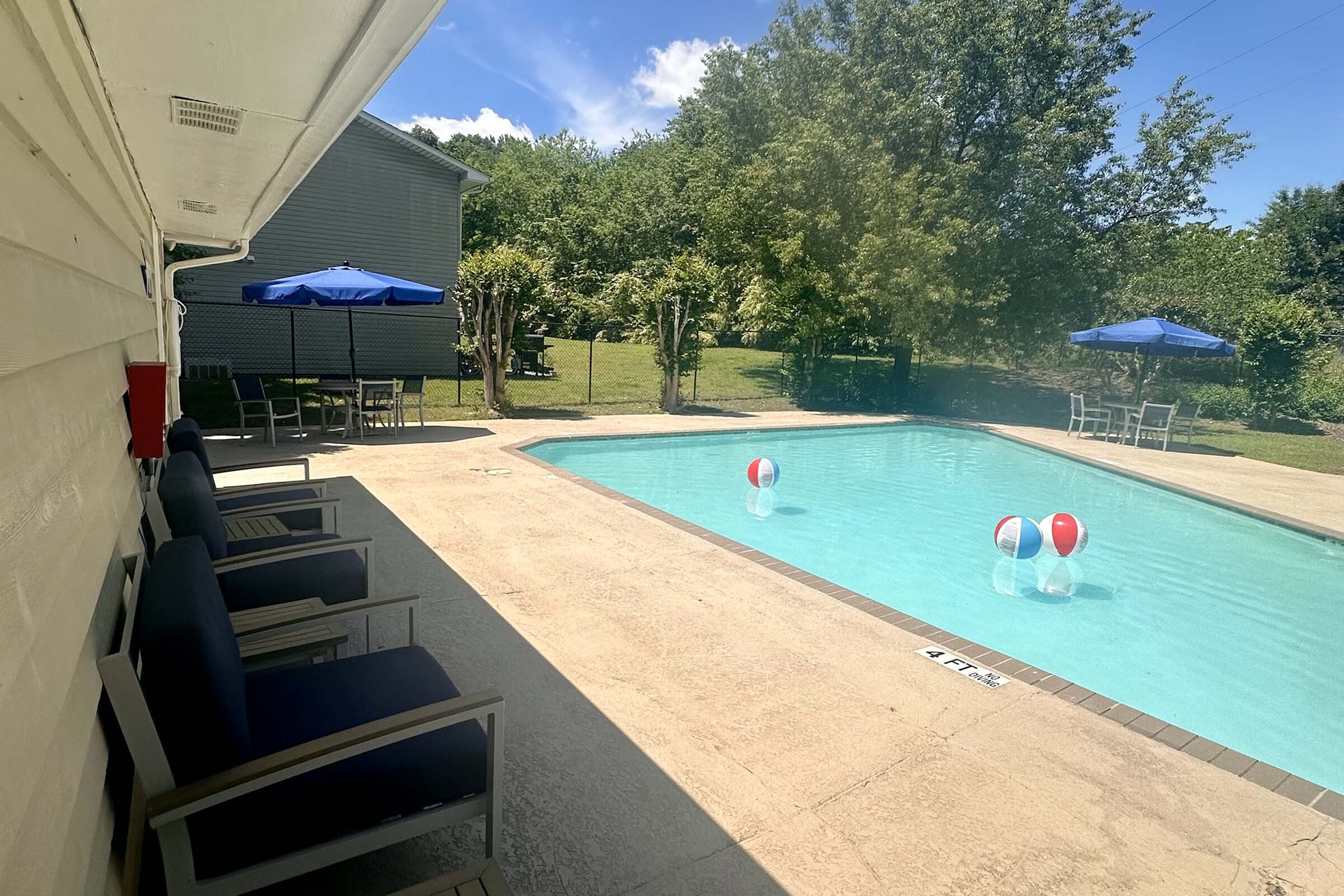 Inviting outdoor pool area with cozy seating and vibrant sun umbrellas, perfect for relaxation and enjoying the sunny days.