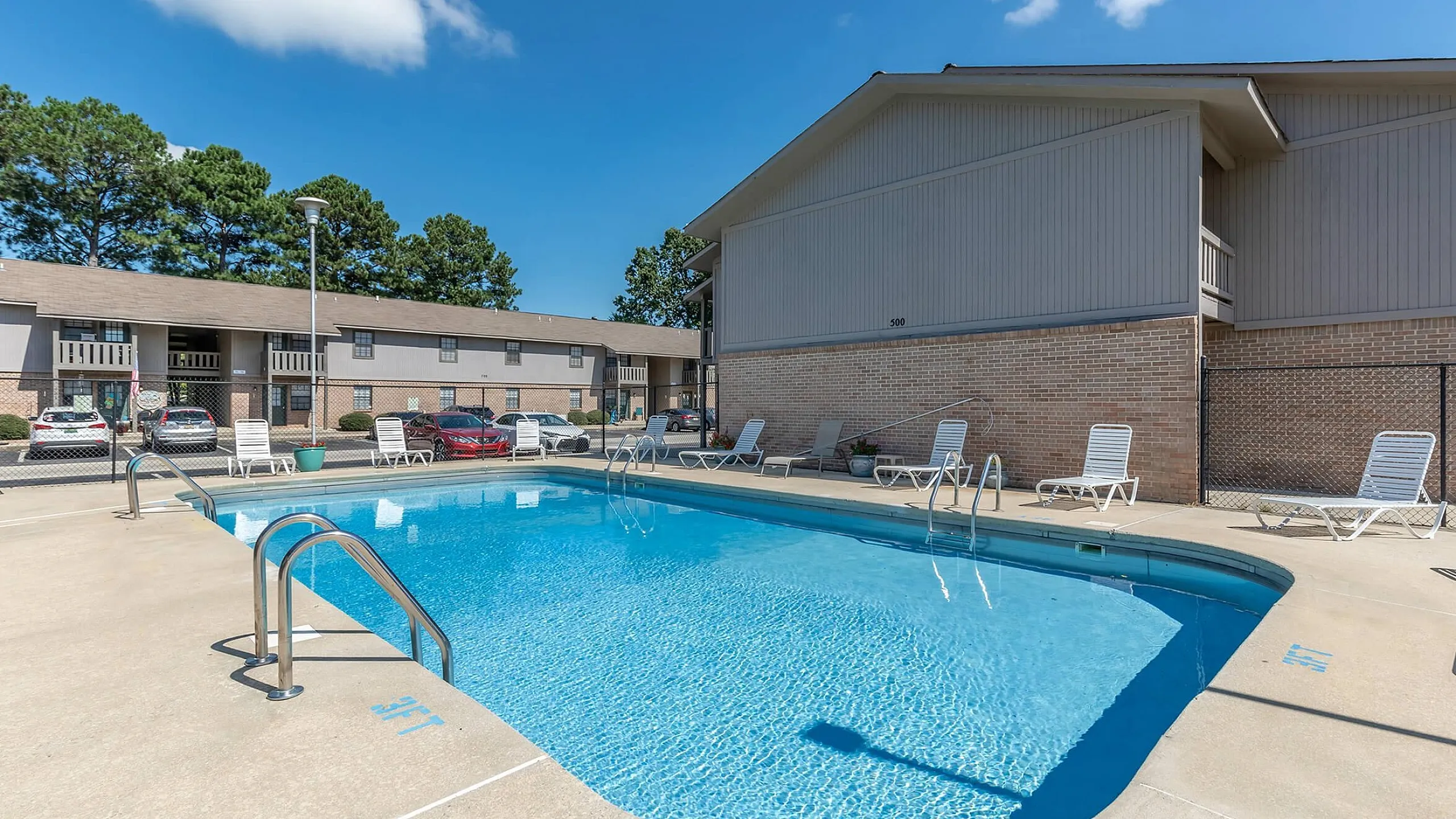 Inviting outdoor pool area with sun loungers and clear blue water, perfect for relaxation and enjoyment.