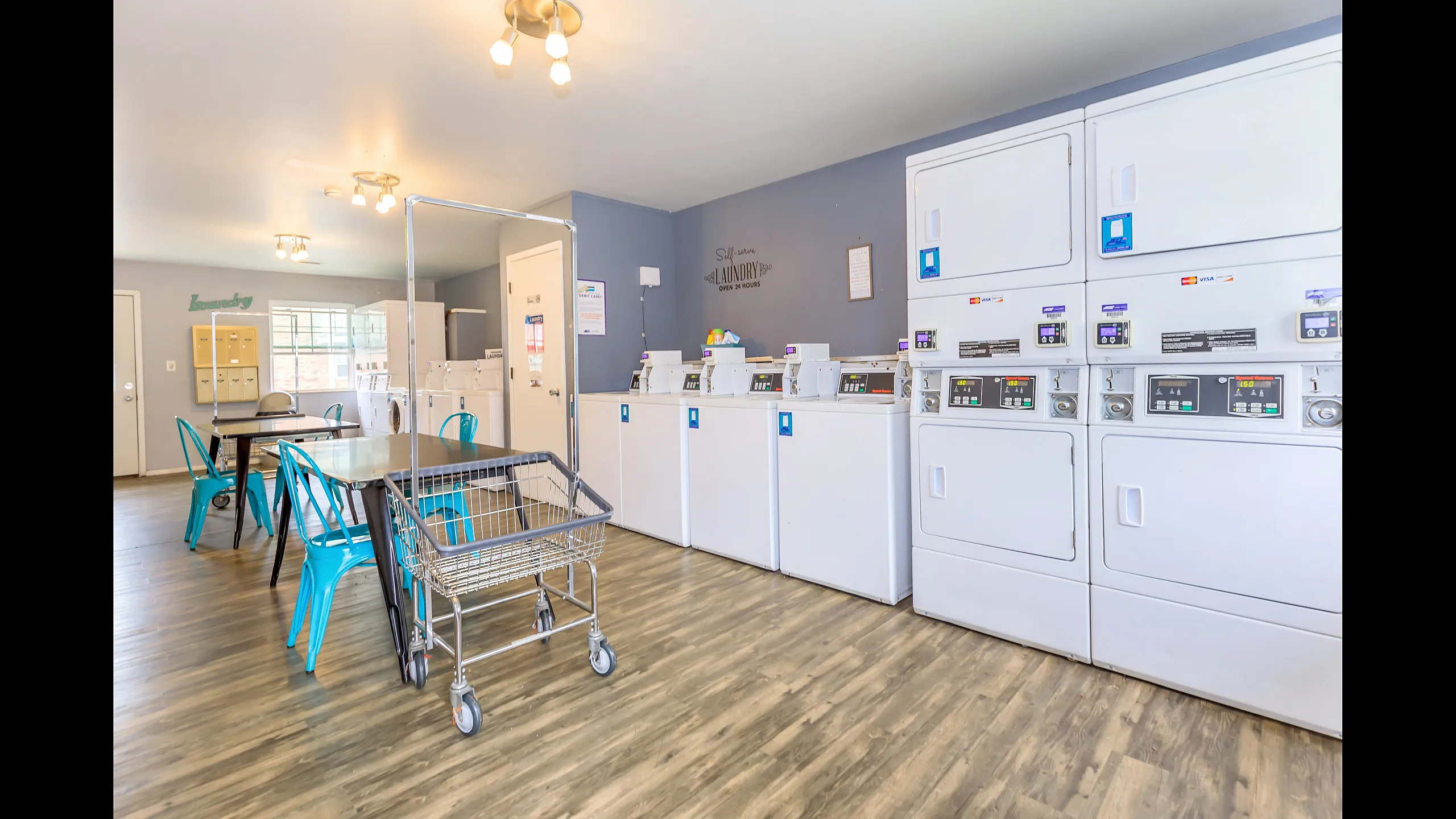 Contemporary communal laundry room with efficient washers, dryers, and stylish seating, offering convenience and comfort.