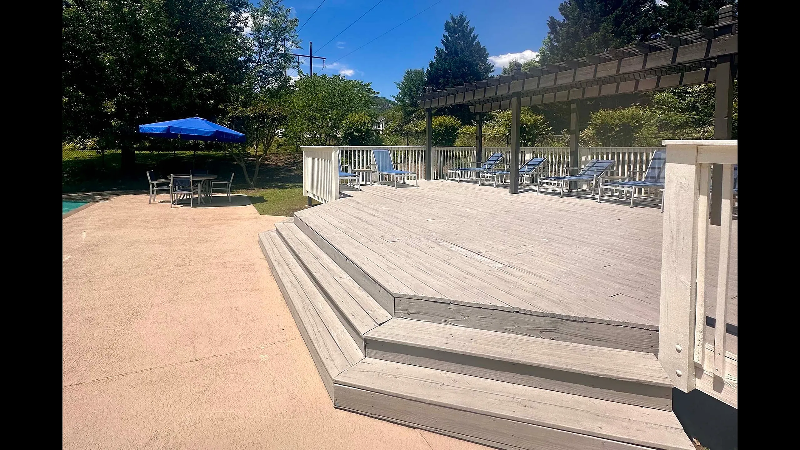Inviting outdoor deck with lounge chairs and a shaded seating area, perfect for relaxation under a sunny sky.