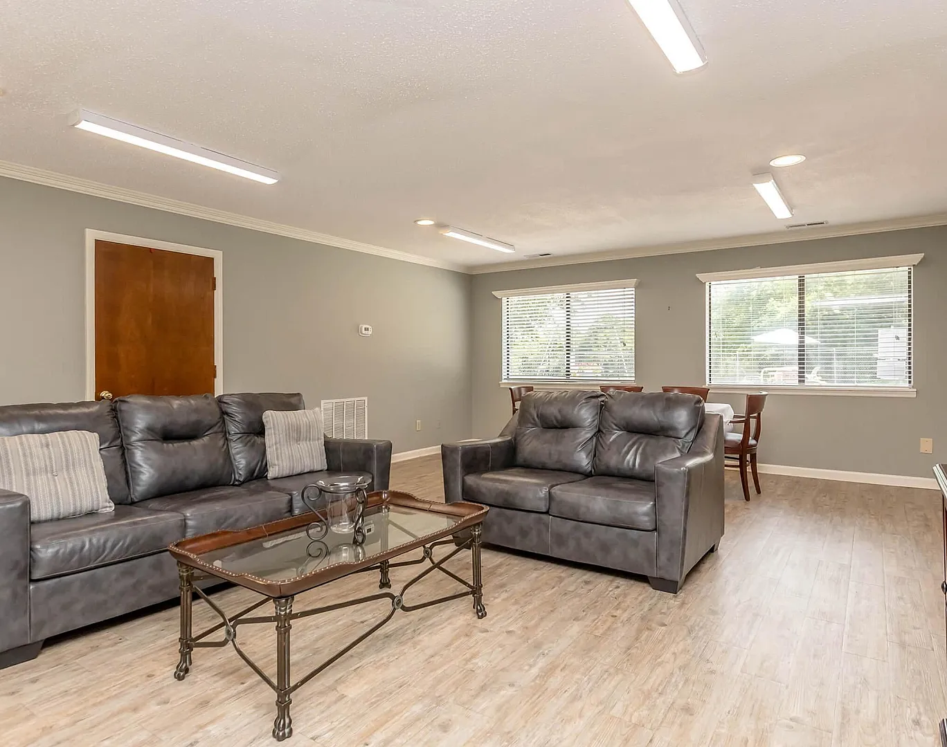 Bright and inviting living room with sleek leather sofas and large windows offering lush views.