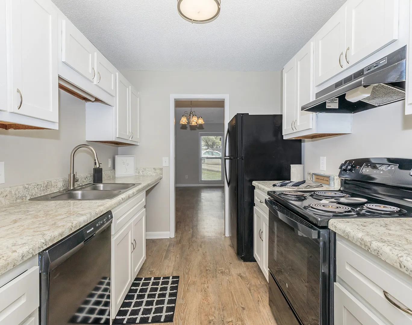 Modern galley kitchen with sleek appliances, ample cabinetry, and elegant granite countertops, offering a bright and inviting cooking space.