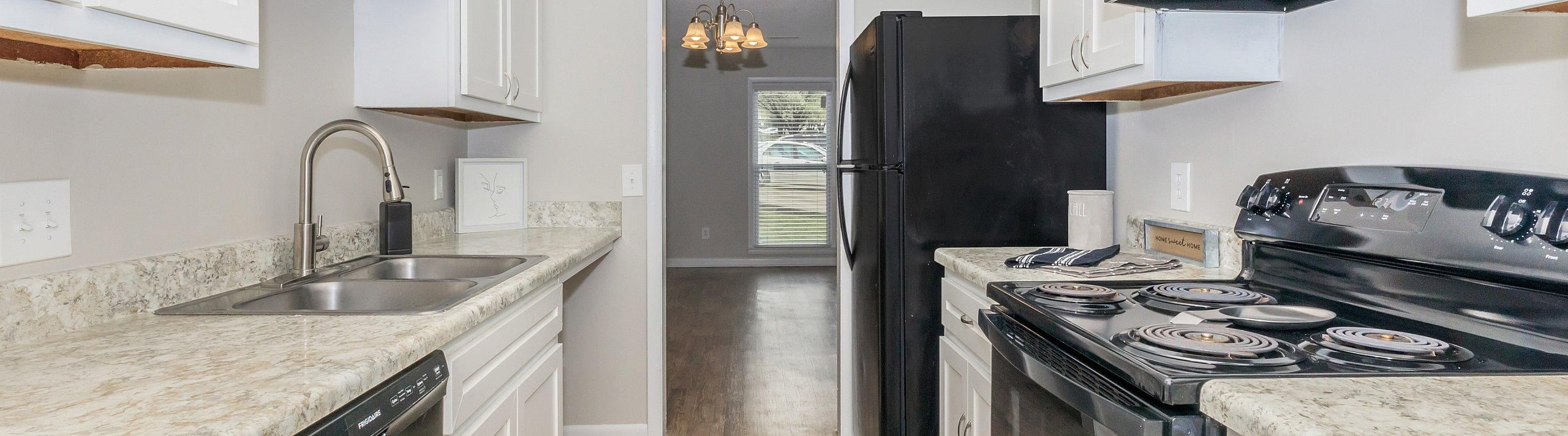 Sleek kitchen with modern appliances, stylish granite countertops, and abundant white cabinetry offers a bright and welcoming culinary space.