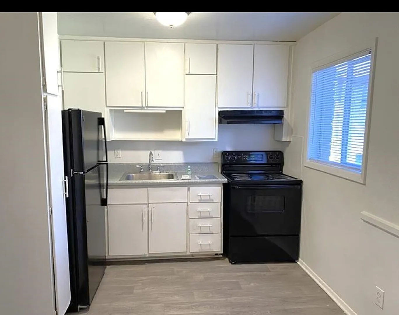 Charming and bright kitchen with modern appliances, sleek cabinetry, and a cozy window view.