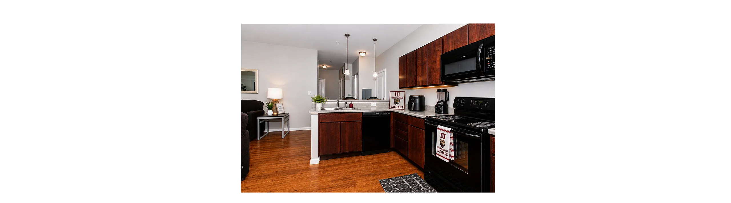 Modern kitchen with dark wood cabinetry, sleek appliances, and an invitingly cozy atmosphere, perfect for culinary adventures.