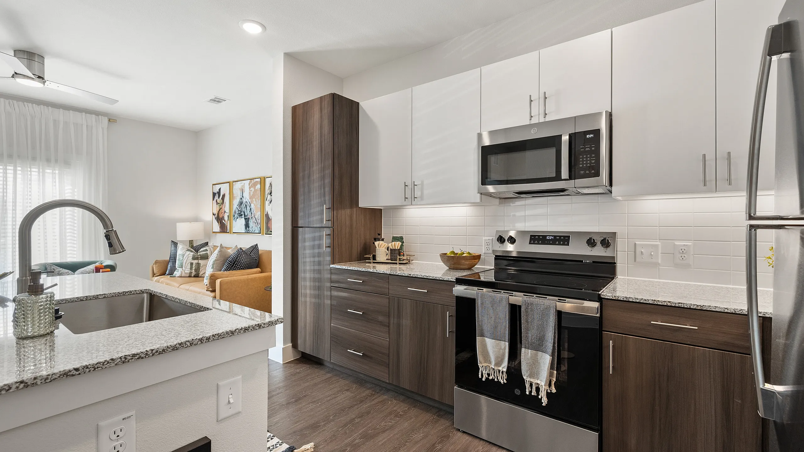 Chic apartment kitchen with modern appliances, sleek cabinetry, and an inviting open-concept living area.