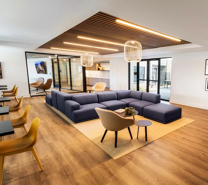 Modern living room with sleek wood flooring, a spacious L-shaped sofa, and contemporary decor, perfect for entertaining.