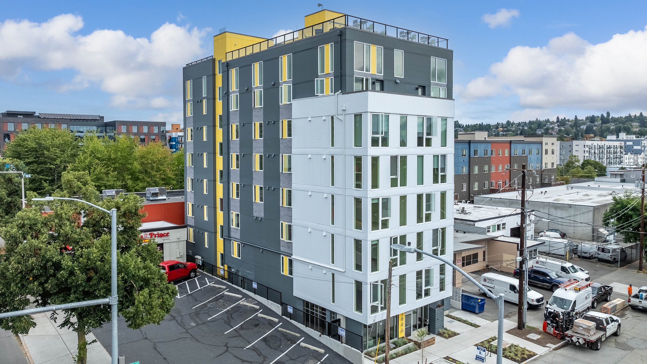 Contemporary urban apartment building with vibrant yellow accents, offering panoramic city views and modern architecture.