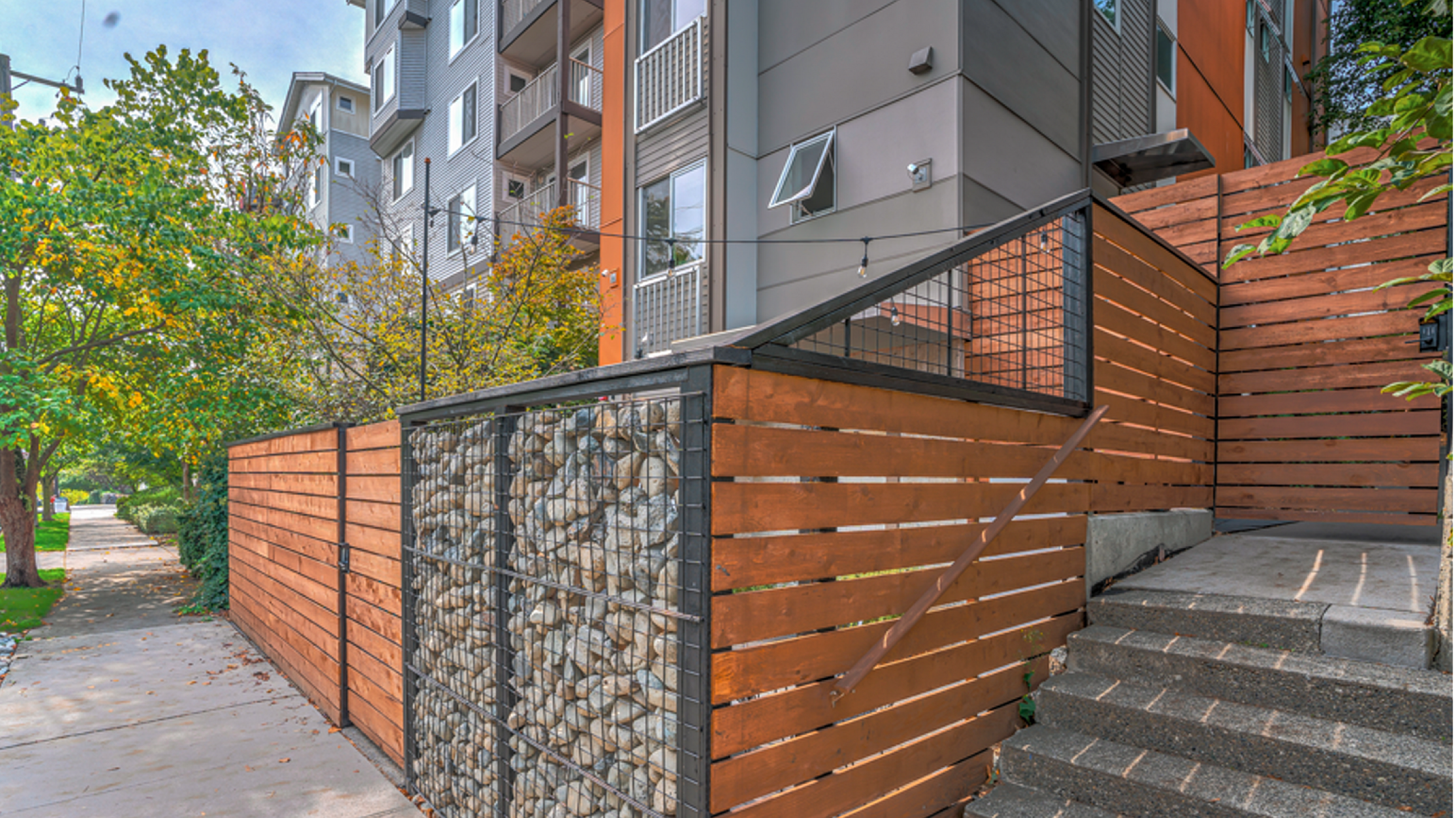 Inviting apartment exterior with modern architecture, natural stone accents, and well-maintained greenery for serene urban living.