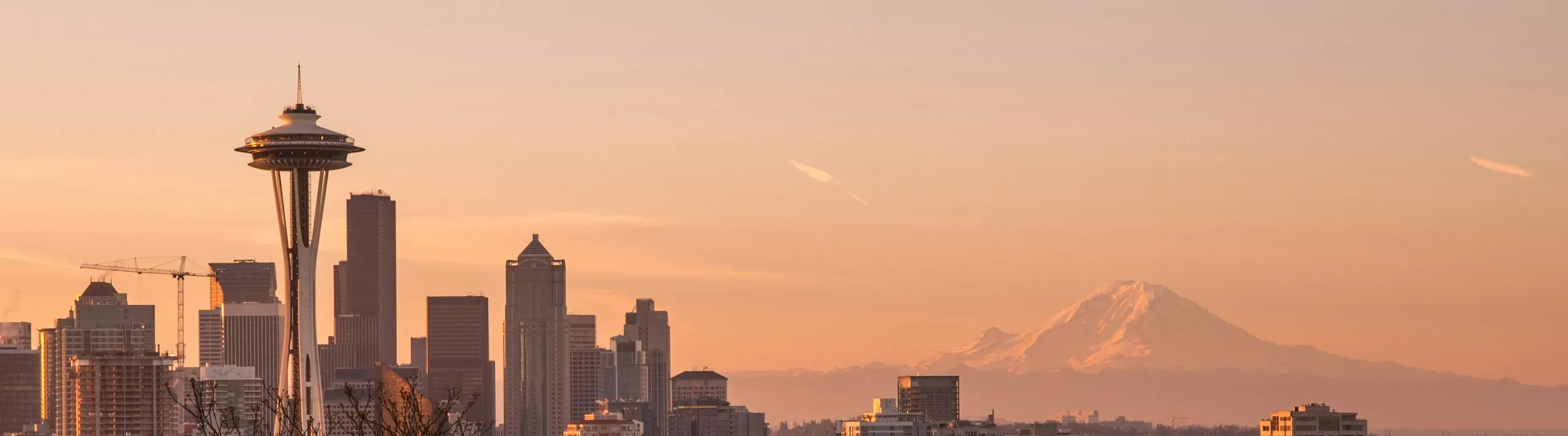 Breathtaking Seattle skyline at sunset with iconic Space Needle and majestic Mount Rainier in the background.