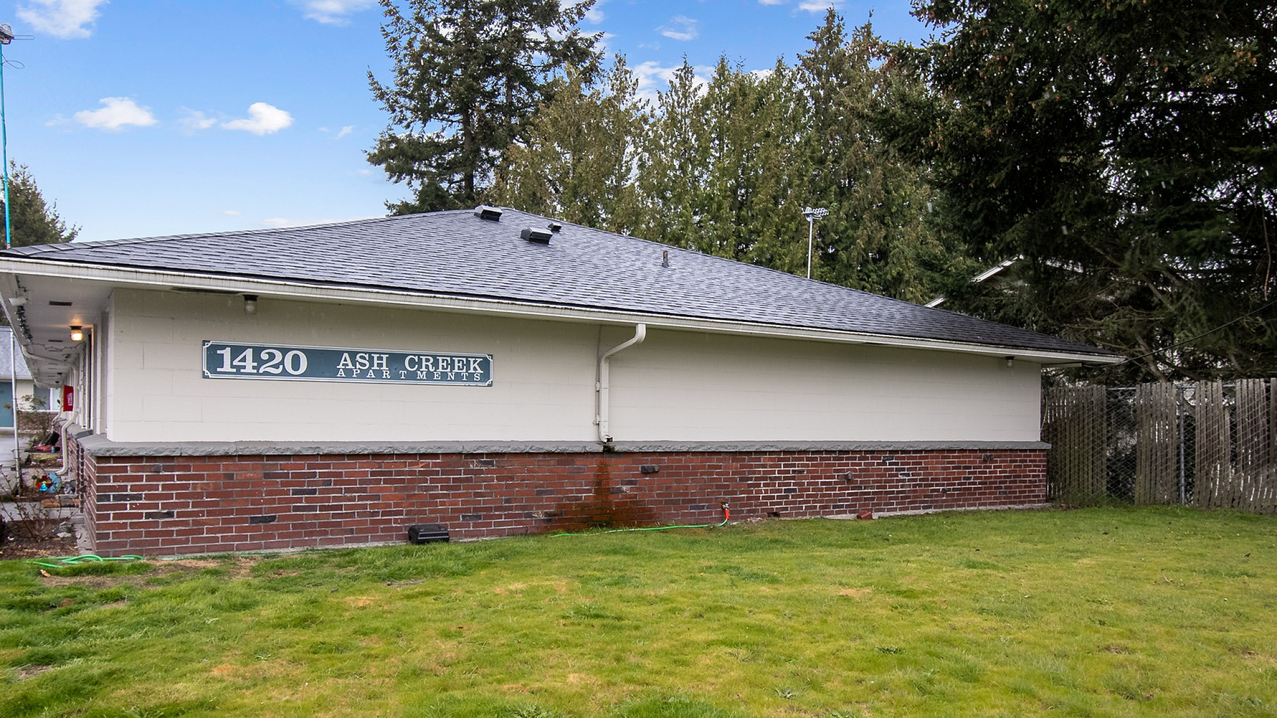 Charming Ash Creek Apartments surrounded by lush greenery and a peaceful ambiance, perfect for tranquil living.