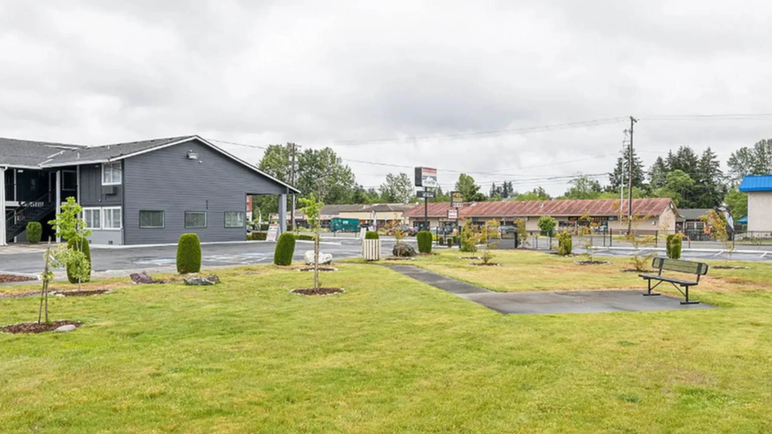 Charming apartment exterior with lush green lawns and modern architecture, offering a peaceful and inviting environment.