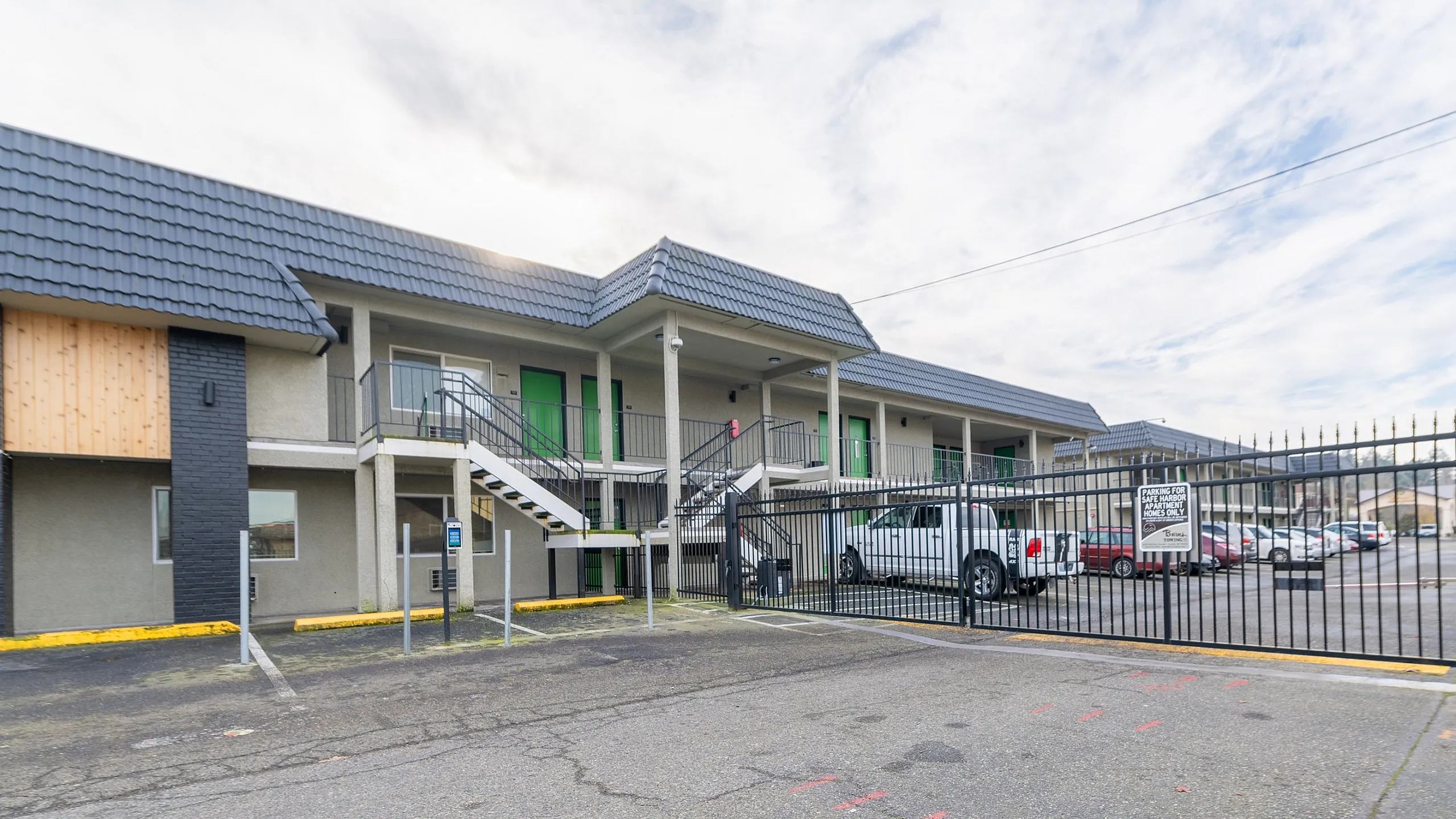 Secure and modern apartment complex with charming exterior design, ample parking, and gated access for added peace of mind.