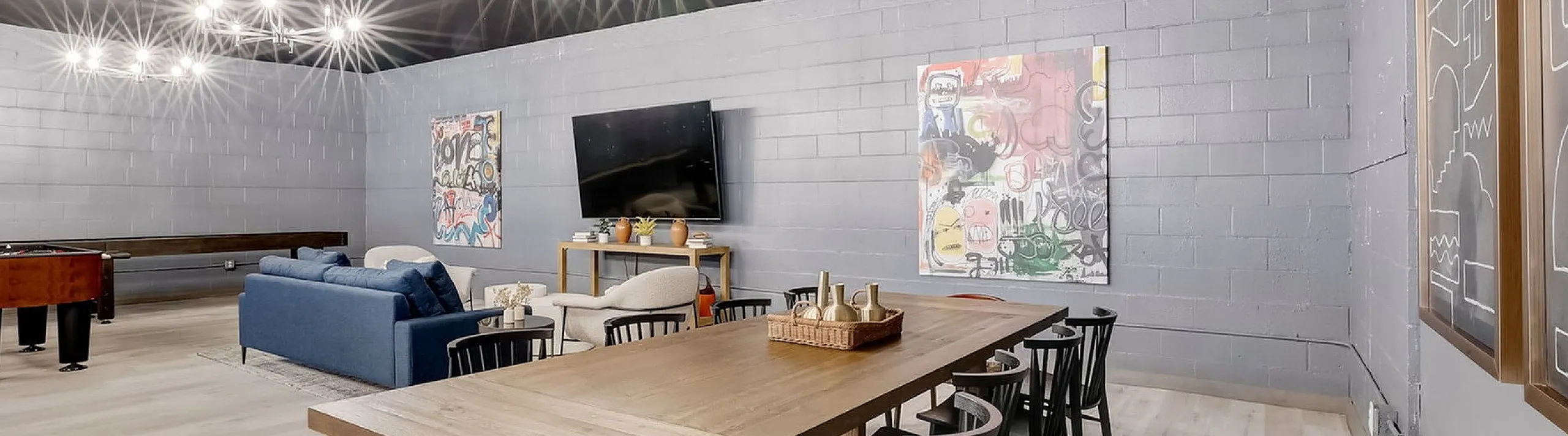 Spacious and modern entertainment room with chic lighting, stylish seating, and contemporary artwork.